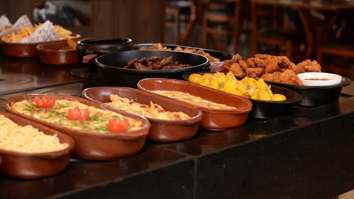 Buffet do Restaurante Complexo 34 com travessas de massas, carnes e acompanhamentos