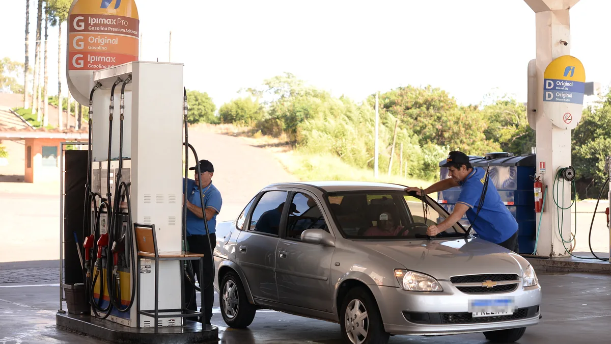 Frentista abastecendo carro na pista do Posto Ipiranga do Complexo 34, na BR-386